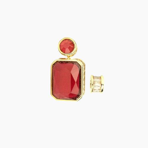 Gold earring with red gemstone on a white background