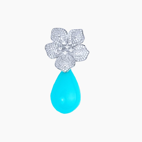 Jewelry pendant with floral design and turquoise teardrop on a white background