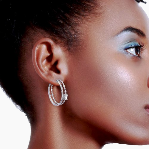 Close-up of a woman wearing a silver hoop earring on a white background