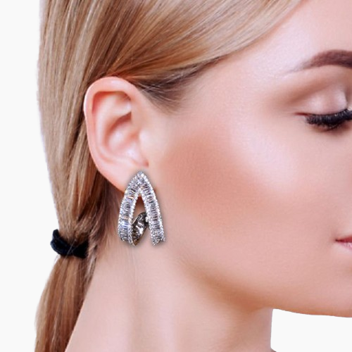 Close-up of a woman wearing a silver hoop earring with a blurred background