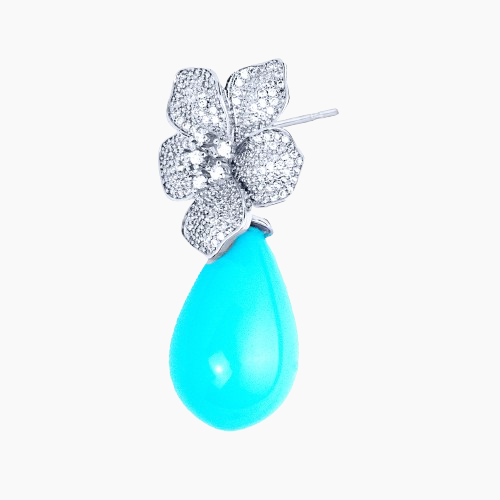 Earring with turquoise teardrop and diamond-studded floral design on a white background