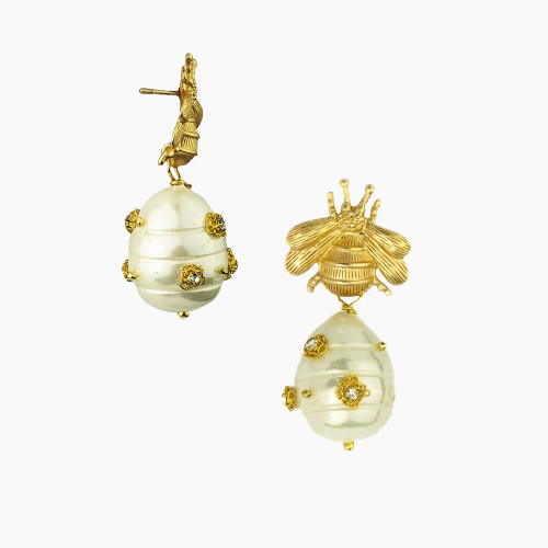 Gold and pearl earrings with bee design on a white background