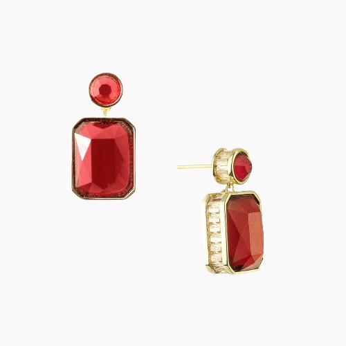 Gold earrings with red gemstones on a white background